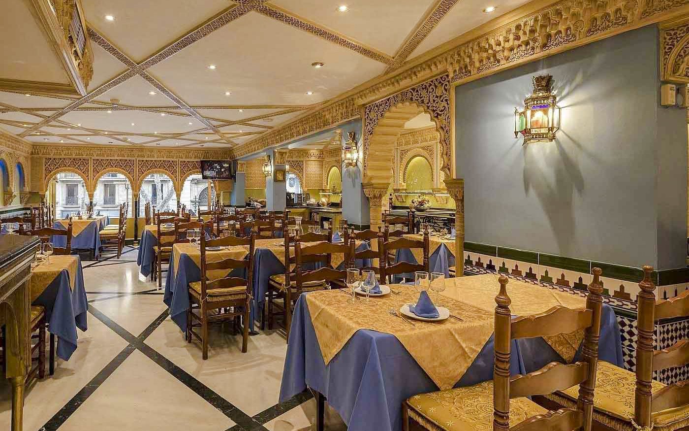 Interior of Tablao Cordobes with ornate decor and set dining tables.