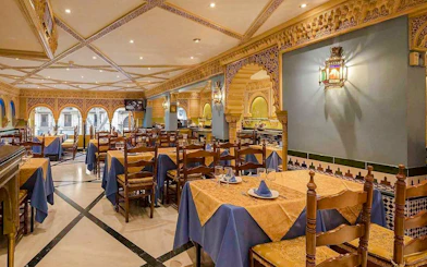 Interior of Tablao Cordobes with ornate decor and set dining tables.