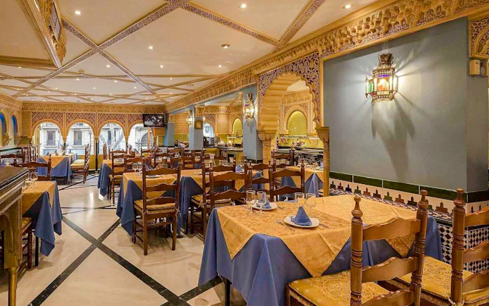 Interior of Tablao Cordobes with ornate decor and set dining tables.