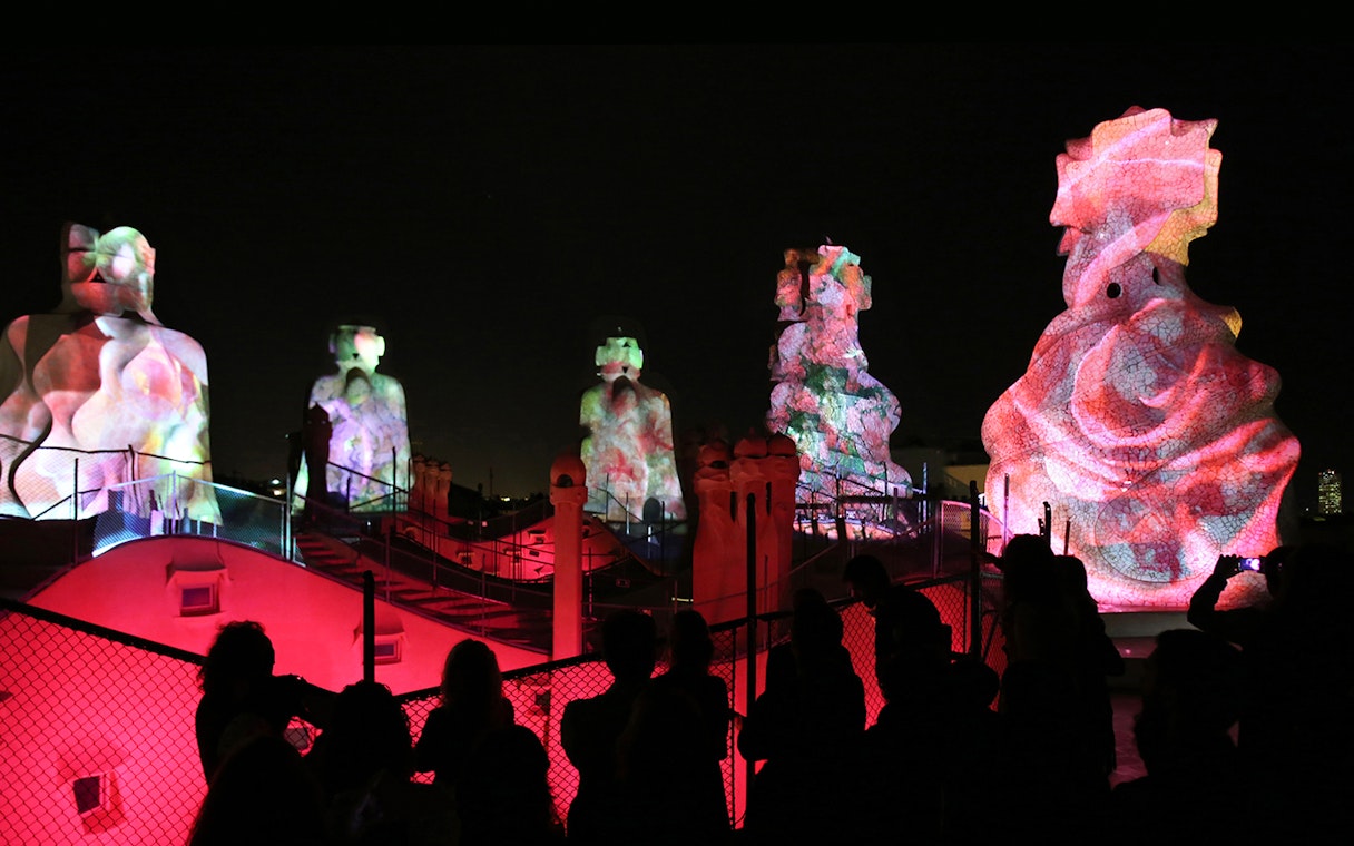 Casa Mila rooftop sculptures illuminated during La Pedrera Night Experience in Barcelona.