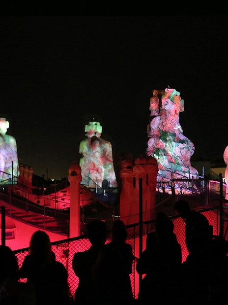 Casa Mila rooftop sculptures illuminated during La Pedrera Night Experience in Barcelona.