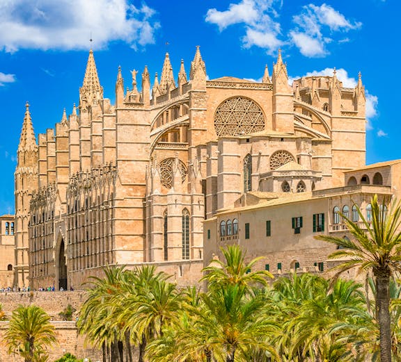 Royal Palace of La Almudaina with palm trees in Palma, Mallorca.