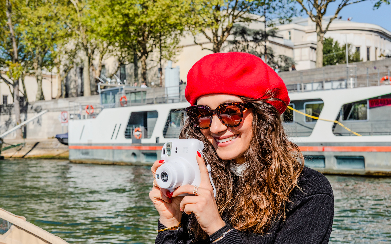 Person taking a Polaroid photo on the Seine River during the Emily in Paris Champagne Cruise.