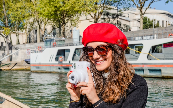 Person taking a Polaroid photo on the Seine River during the Emily in Paris Champagne Cruise.