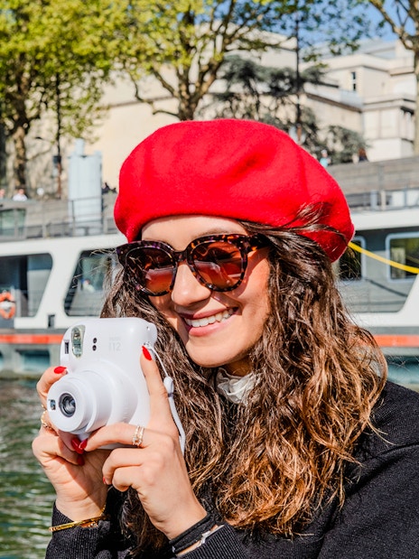 Person taking a Polaroid photo on the Seine River during the Emily in Paris Champagne Cruise.