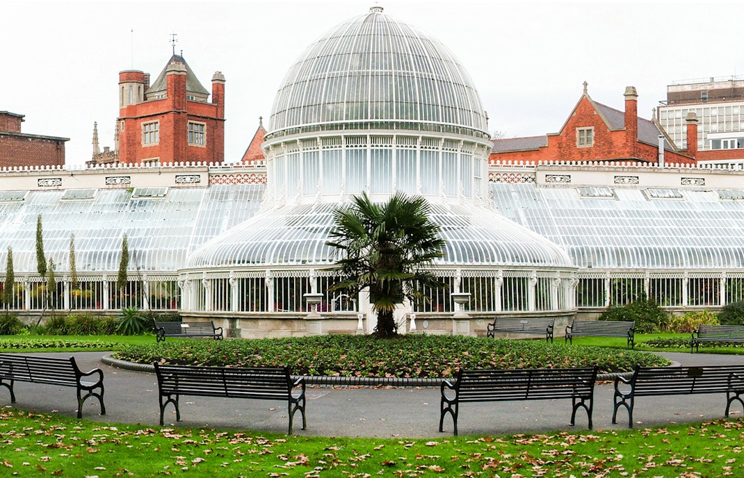Belfast Botanic Gardens glasshouse with vibrant flowers and lush greenery.