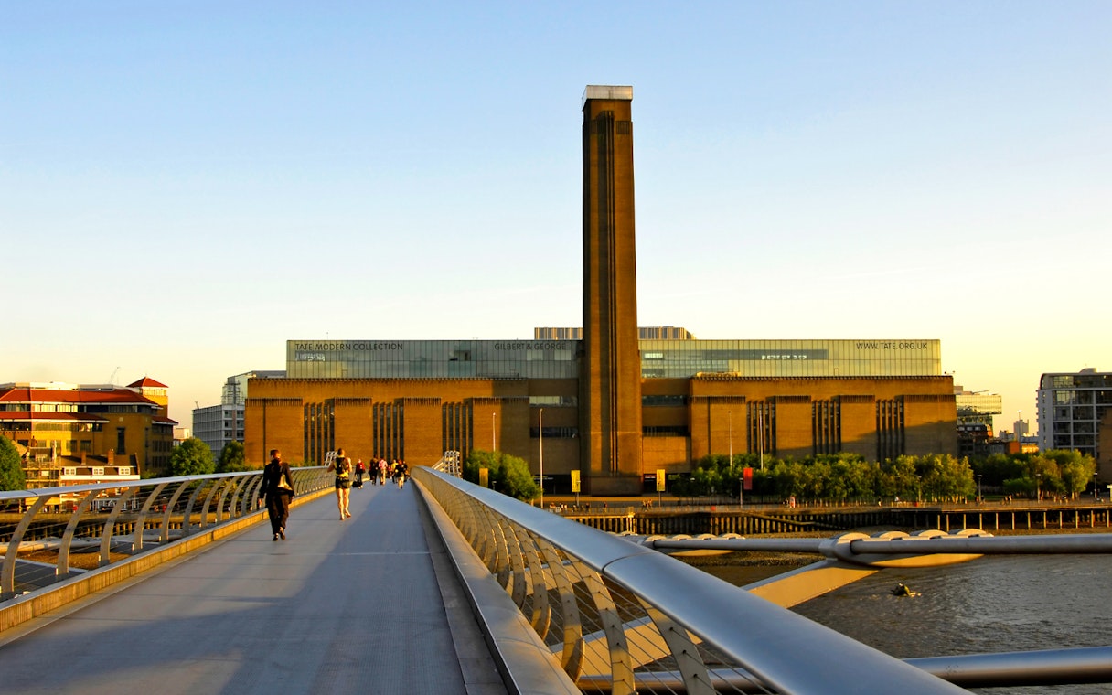 Millennium Bridge leading to Tate Modern in London at sunset.