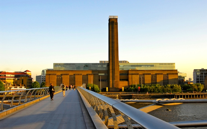 Millennium Bridge leading to Tate Modern in London at sunset.