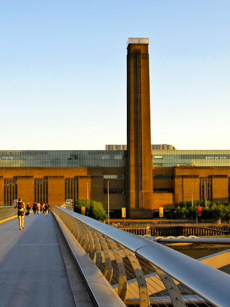 Millennium Bridge leading to Tate Modern in London at sunset.
