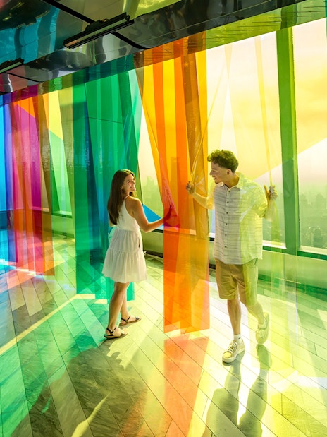 Couple exploring colorful installation at Edge Observation Deck, New York City.