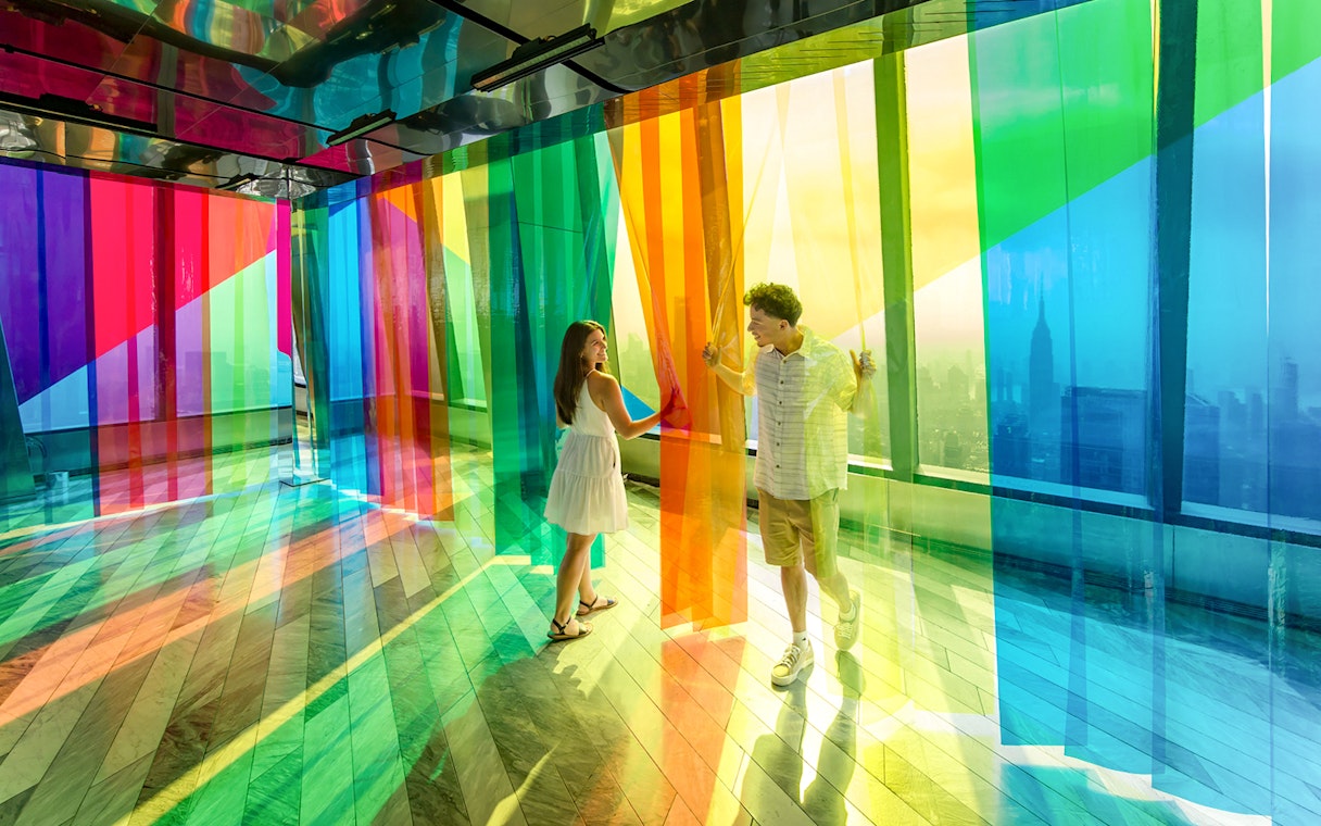 Couple exploring colorful installation at Edge Observation Deck, New York City.