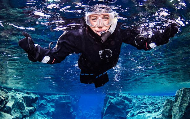 Snorkeler exploring clear waters between tectonic plates in Iceland.