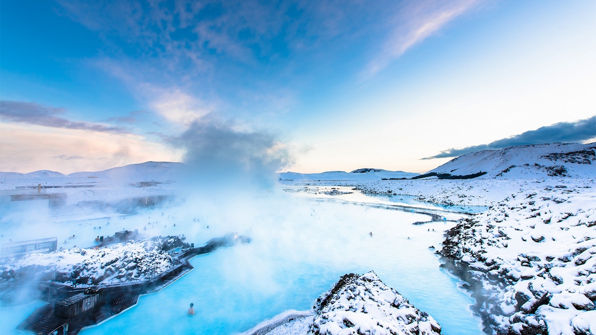 Blue Lagoon hot spring spa with steam rising, surrounded by snowy landscape in Iceland.