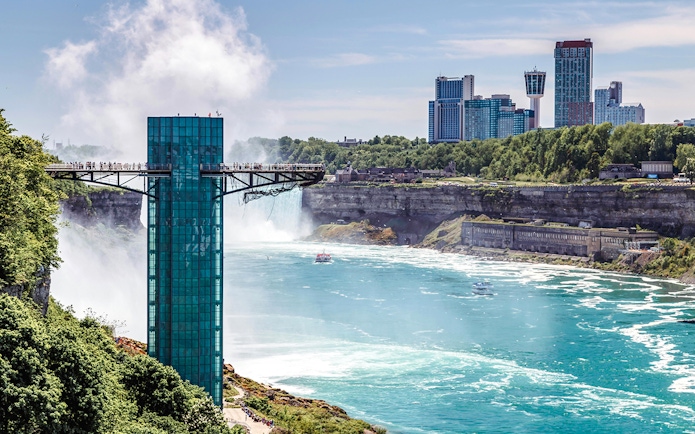 Observation deck at Prospect Point overlooking Niagara Falls, USA with city skyline in the background.