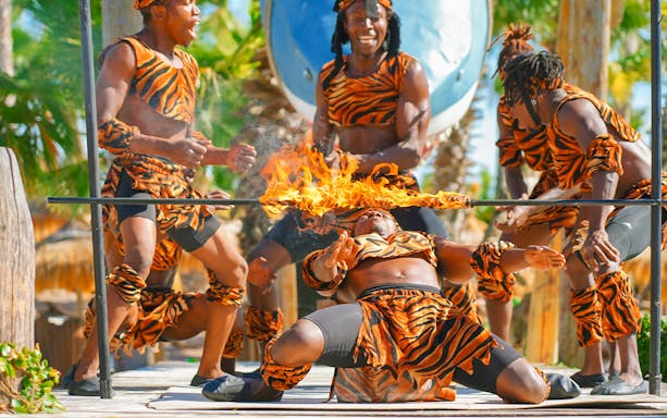 Performer limboing under a flaming bar at Caribe Bay.