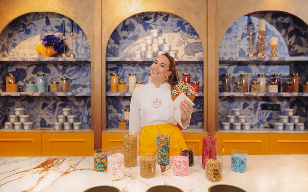 Stroopwafel workshop participant holding decorated waffle in Amsterdam.