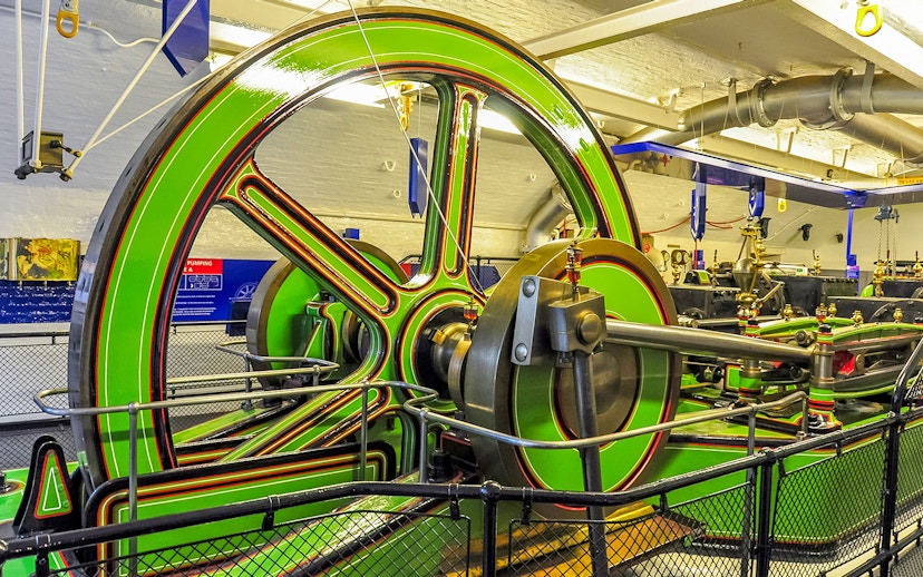 Tower Bridge Engine Room machinery with large green flywheel and pistons.