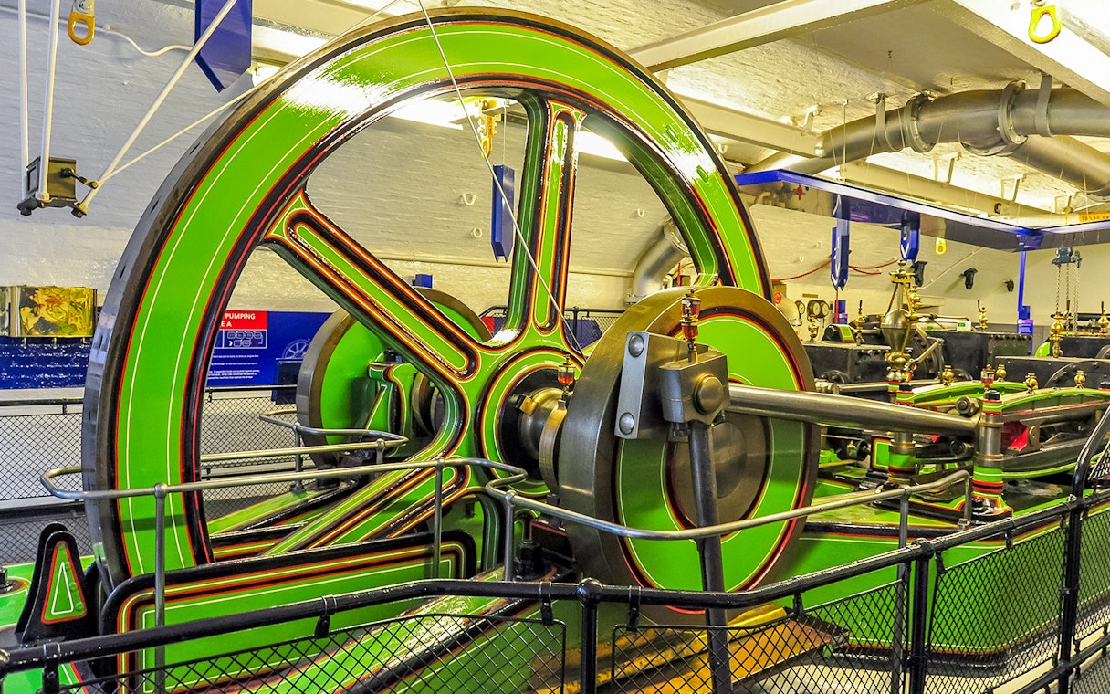 Tower Bridge Engine Room machinery with large green flywheel and pistons.