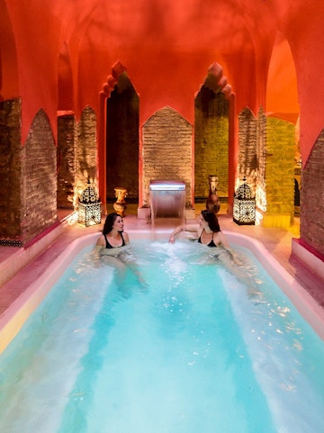 Two women relaxing in a Hammam pool in Granada, Spain.