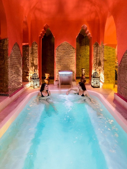 Two women relaxing in a Hammam pool in Granada, Spain.