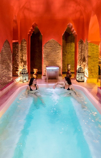 Two women relaxing in a Hammam pool in Granada, Spain.