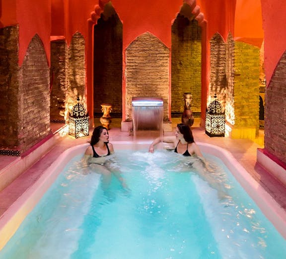 Two women relaxing in a Hammam pool in Granada, Spain.