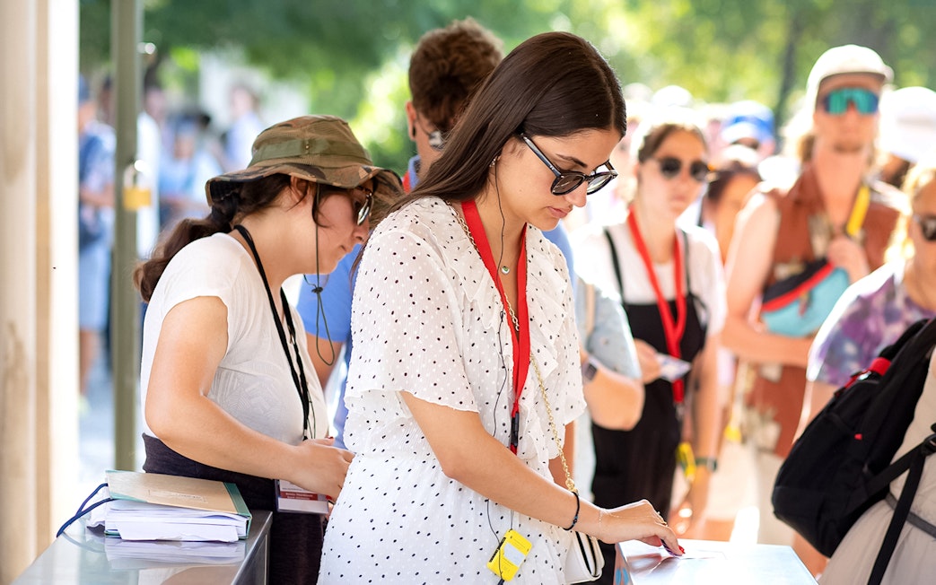 Visitors using audio guides at Acropolis Parthenon entrance.