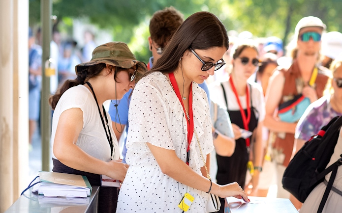 Visitors using audio guides at Acropolis Parthenon entrance.