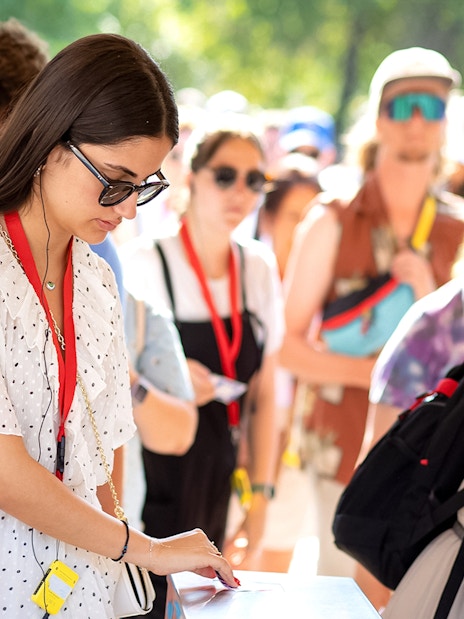 Visitors using audio guides at Acropolis Parthenon entrance.