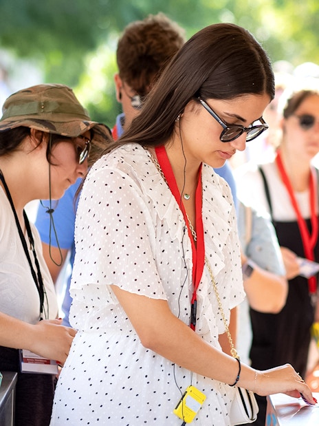 Visitors using audio guides at Acropolis Parthenon entrance.