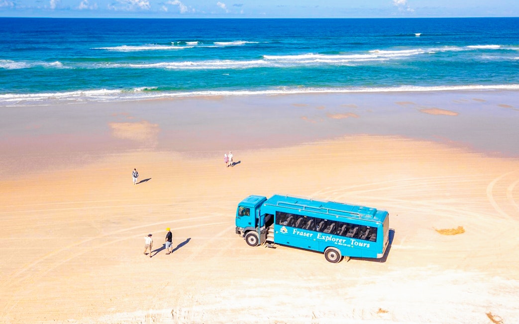 Aerial view of Fraser Island beach with a tour coach and visitors, K'gari.