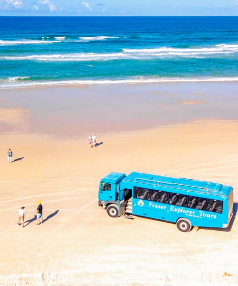 Aerial view of Fraser Island beach with a tour coach and visitors, K'gari.