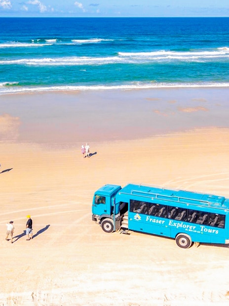 Aerial view of Fraser Island beach with a tour coach and visitors, K'gari.