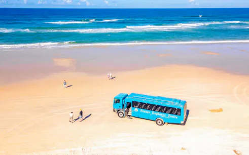 Aerial view of Fraser Island beach with a tour coach and visitors, K'gari.