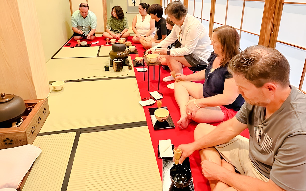 Guests participating in a tea ceremony in a tatami room in Osaka.
