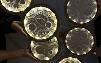 Illuminated moon-themed art pieces held by participants at Glow & Paint Night in Krakow.