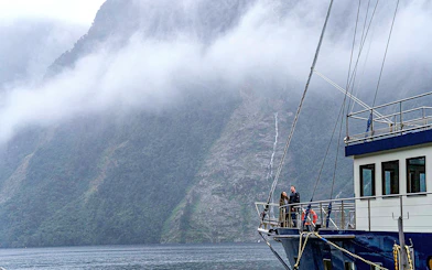 Cruise ship in Doubtful Sound with misty mountains in the background, Te Anau.