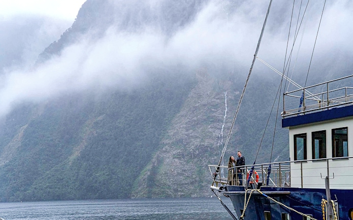 Cruise ship in Doubtful Sound with misty mountains in the background, Te Anau.