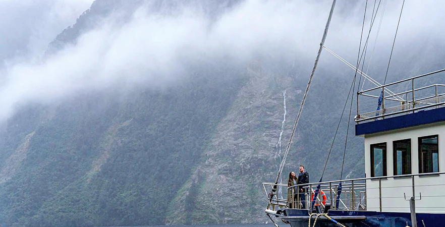 Cruise ship in Doubtful Sound with misty mountains in the background, Te Anau.