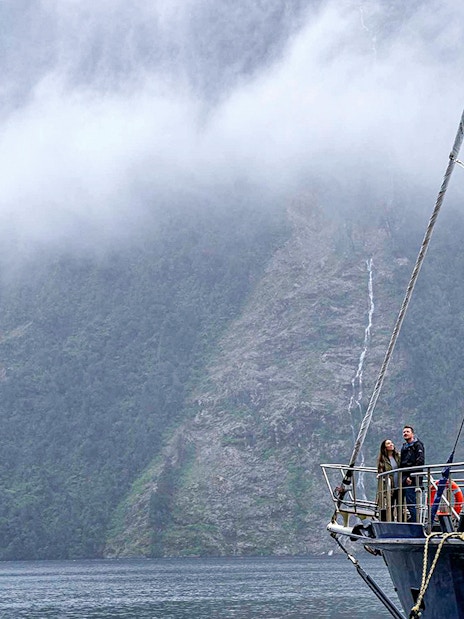 Cruise ship in Doubtful Sound with misty mountains in the background, Te Anau.