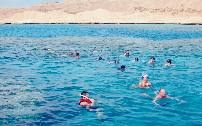 Snorkelers exploring coral reefs and marine life in the Red Sea, Hurghada.