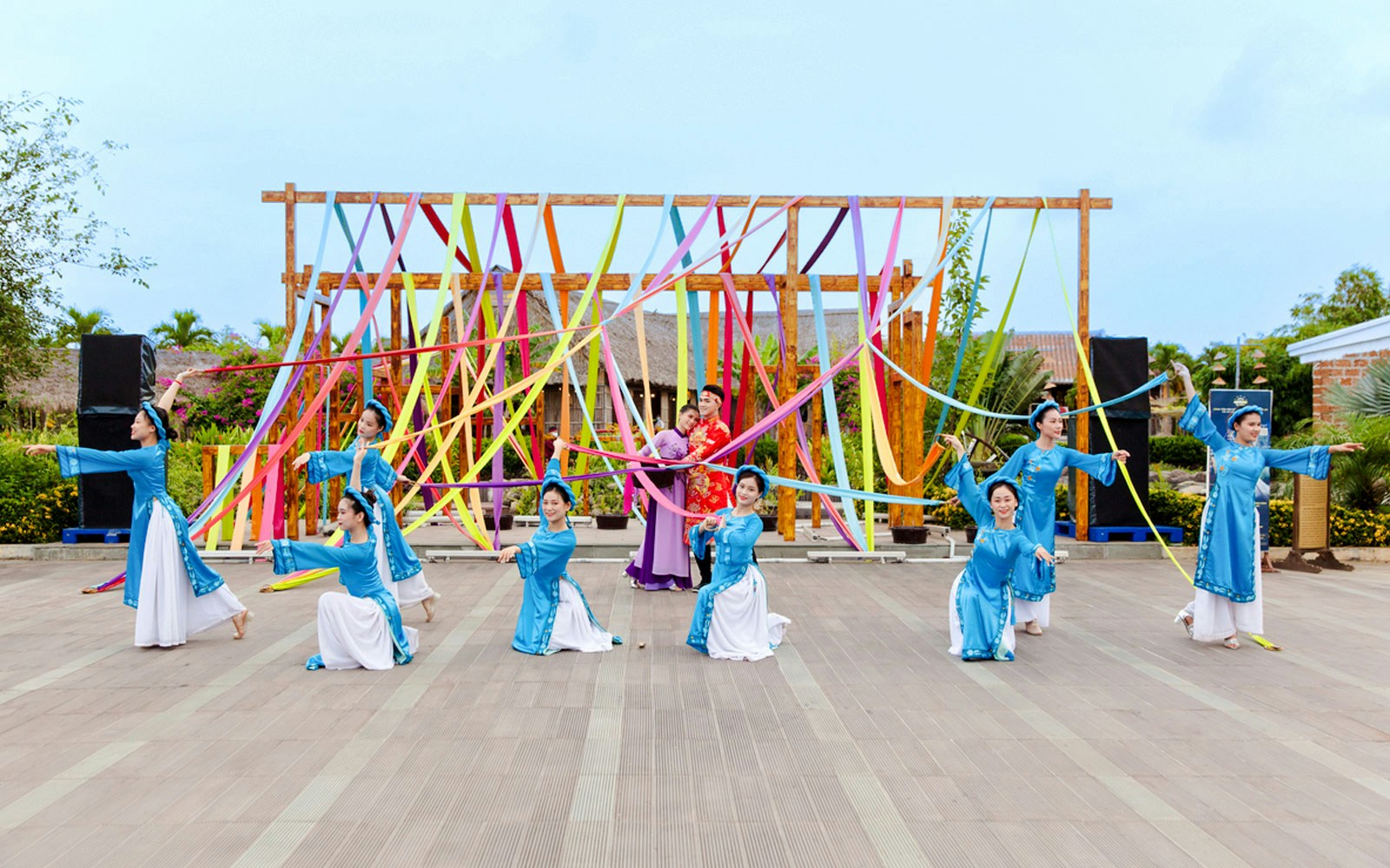 Performers in traditional costumes at Hoi An Memories Show, Vietnam, with colorful ribbons.