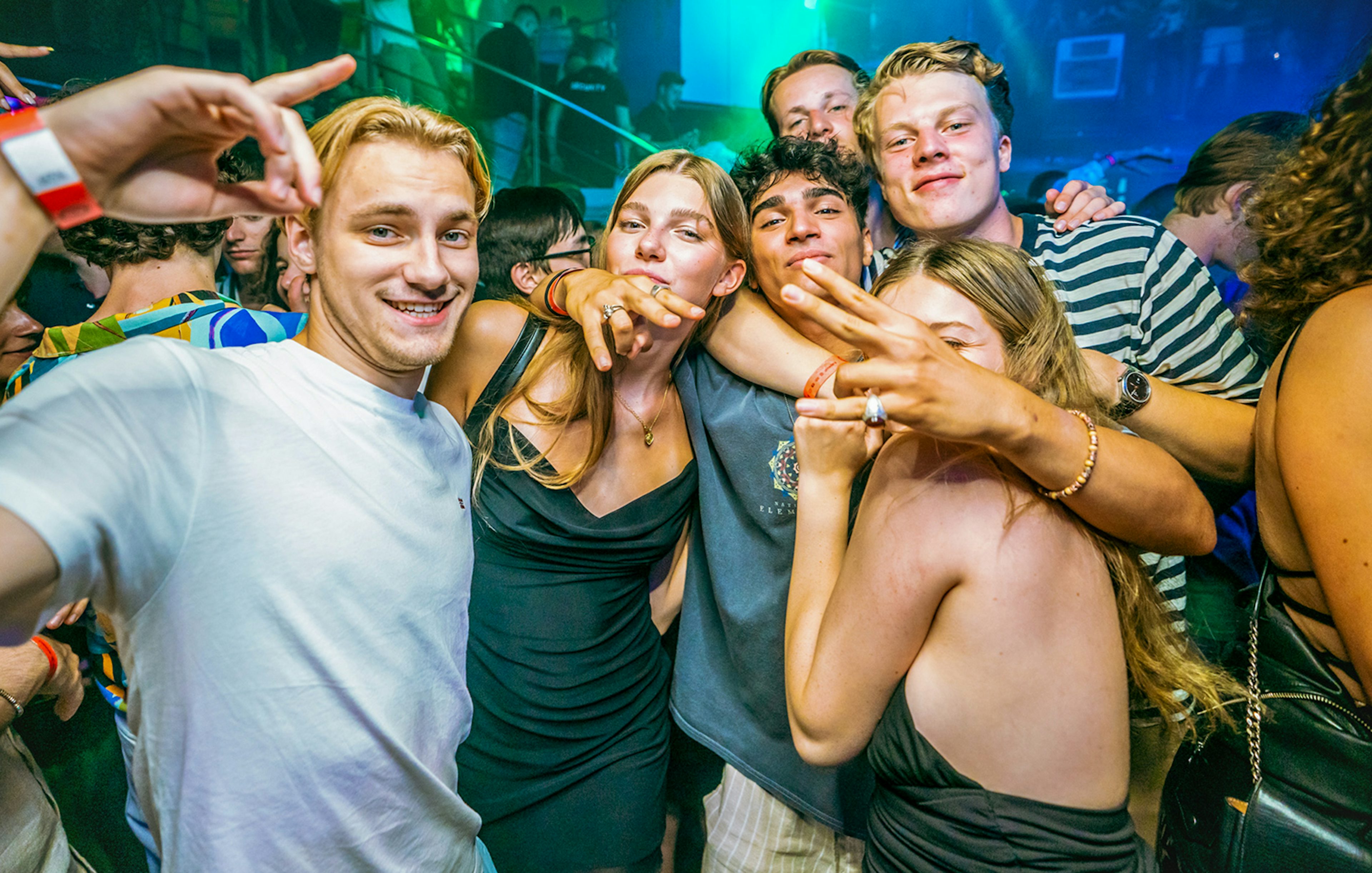 Group of people enjoying a lively boat party in Prague with vibrant lighting.