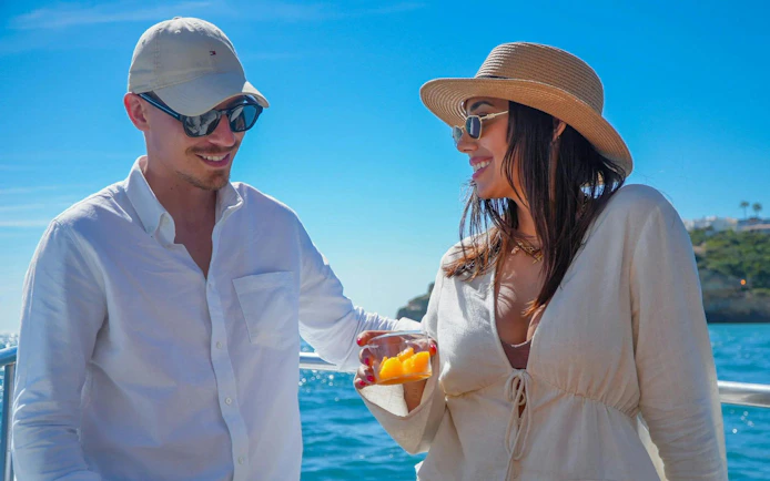 Couple enjoying fruit juice on a boat in Albufeira, Algarve.