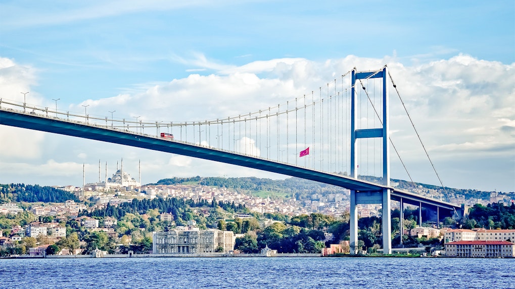 Bosphorus Bridge spanning over the water with Istanbul cityscape in the background.