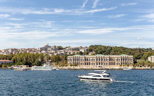 View of a yacht passing by historical palace on Bosphorus