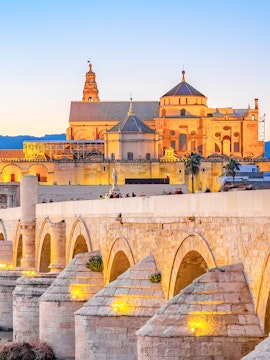 Roman Bridge and Mosque-Cathedral in Cordoba at sunset, part of Seville to Cordoba tours.