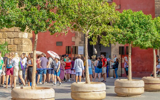 Visitors waiting in line at the entrance of Alcazar in Seville, Spain.