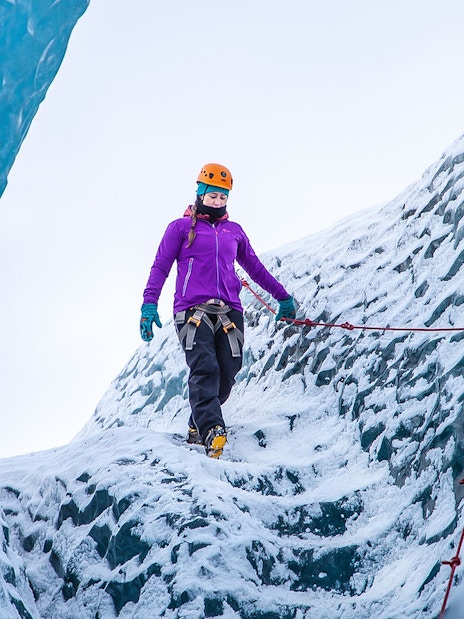 Hiker traversing icy terrain on Falljökull glacier in Iceland.