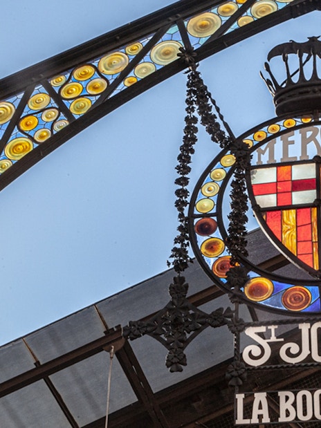 La Boquería market entrance sign with colorful stained glass in Barcelona.